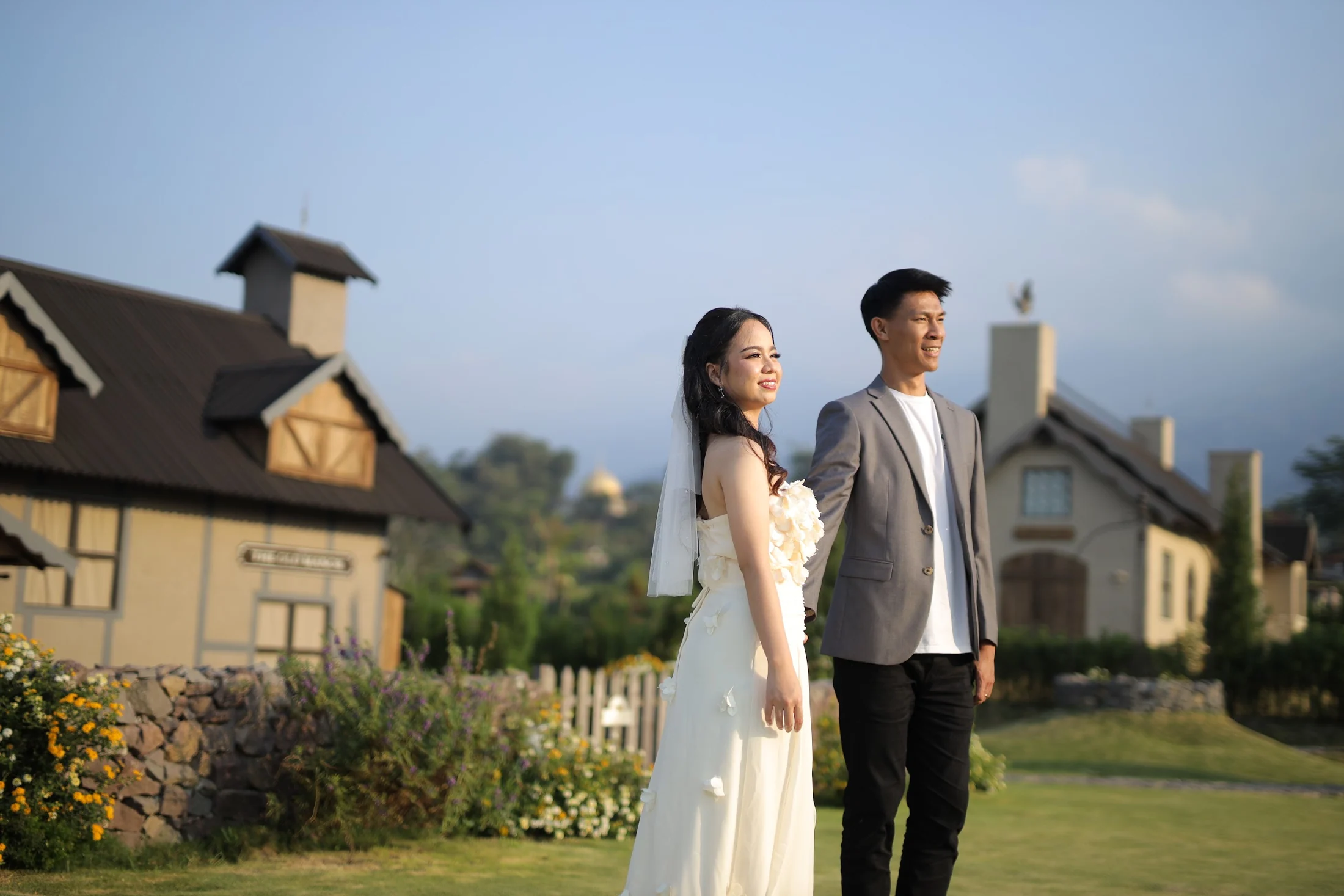 Stefen dalam jas abu-abu dan Jessica dalam gaun putih, berdiri bersama di taman